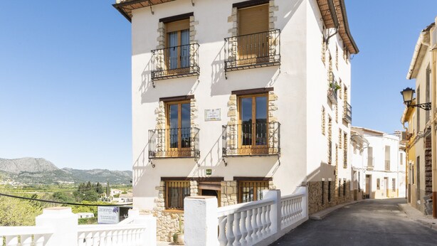 A multi-story building with balconies, a stone facade, and a sign indicating a restaurant. - CARREBAIX V - Cosy studio with free WiFi. (Orba)