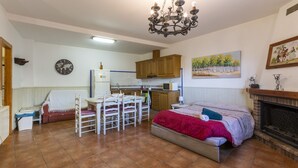 A spacious living room with a bed, a dining area, and a kitchen. - CARREBAIX V - Cosy studio with free WiFi. (Orba)