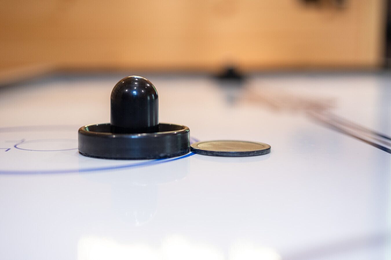 A close-up of a table hockey puck on a table hockey table.
