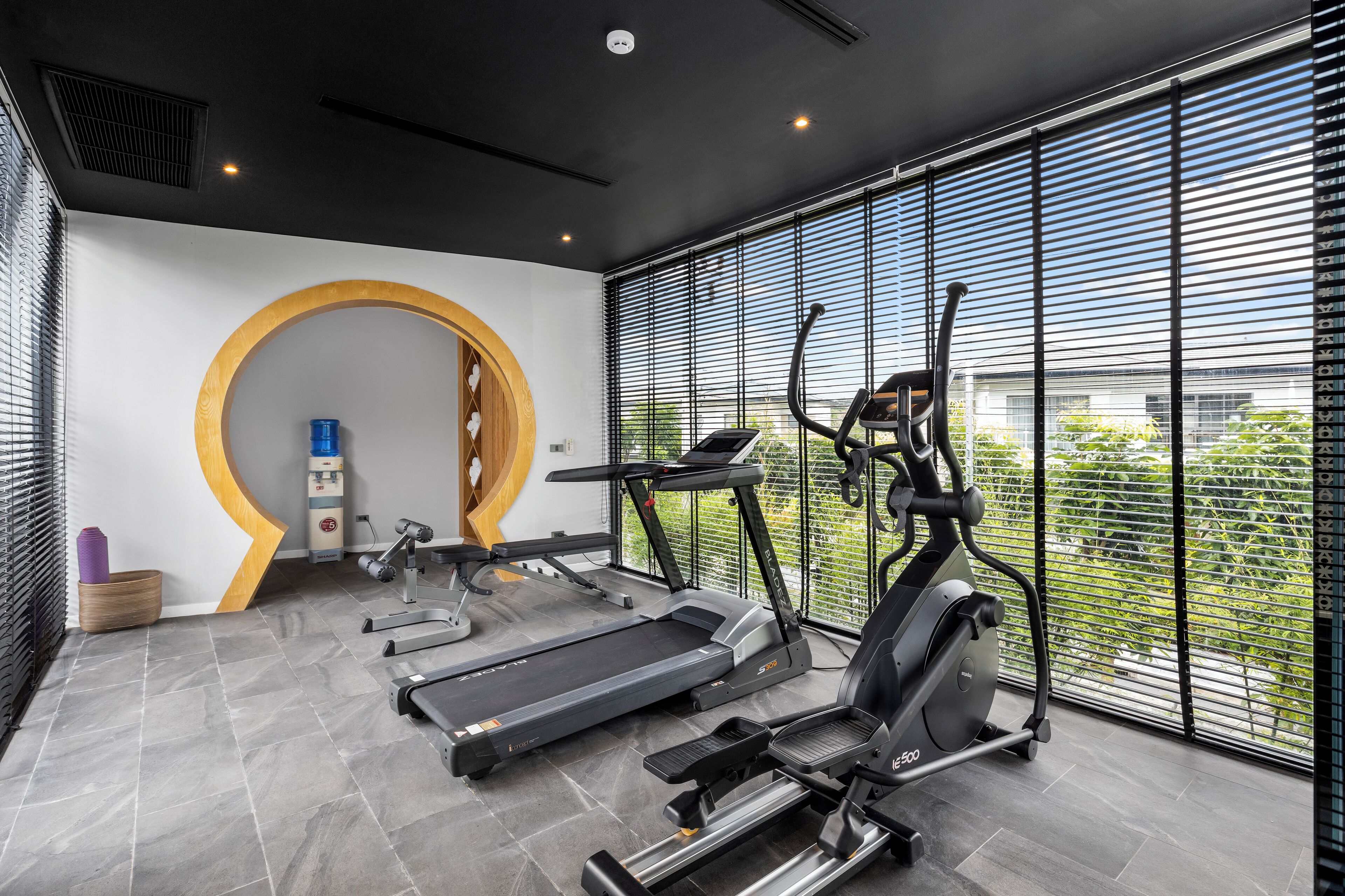 Ein modernes Fitnessstudio mit Laufbändern, Crosstrainern und einem stationären Fahrrad.