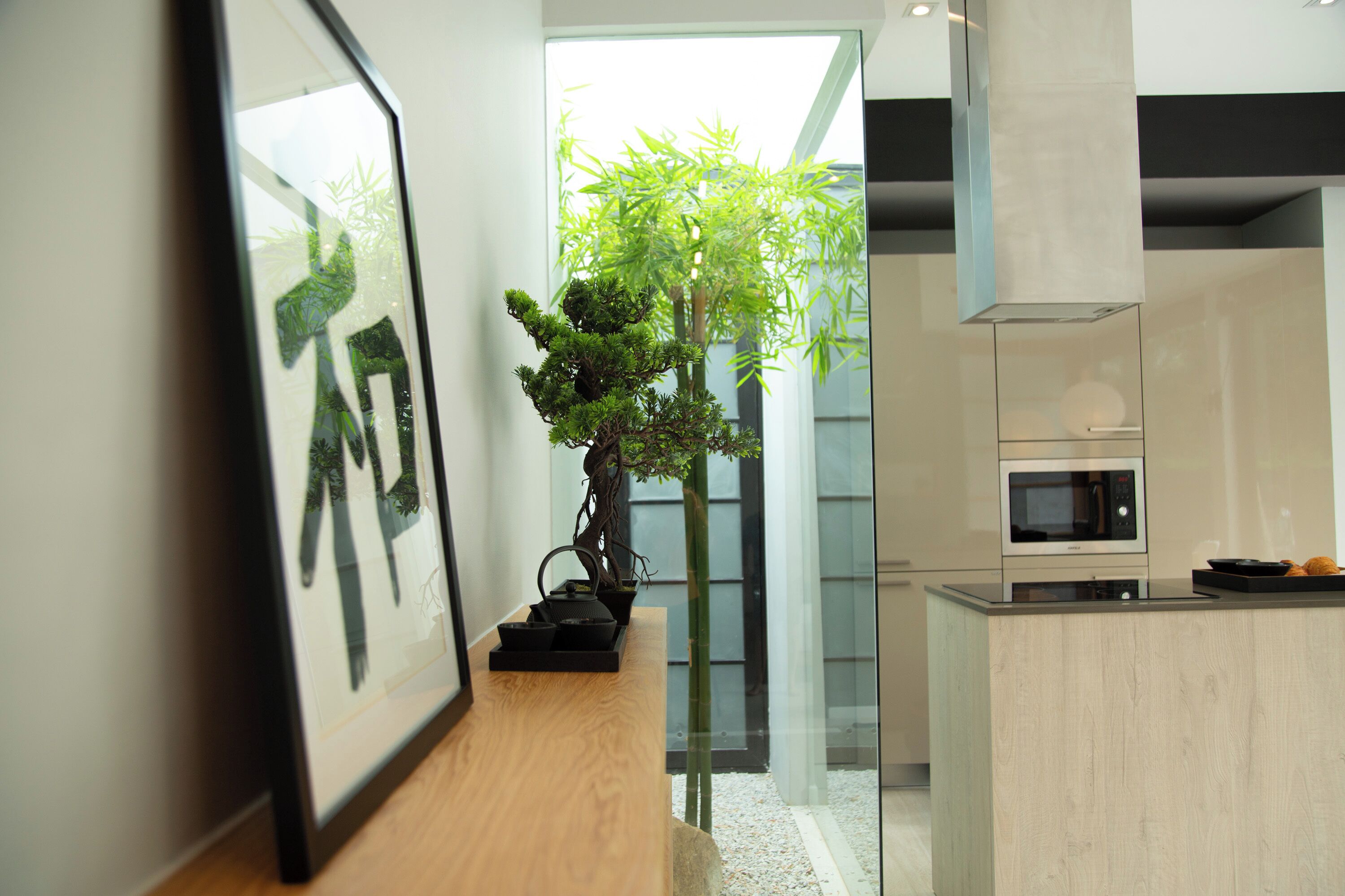 A modern kitchen with a built-in microwave, a wooden countertop, and a small island.