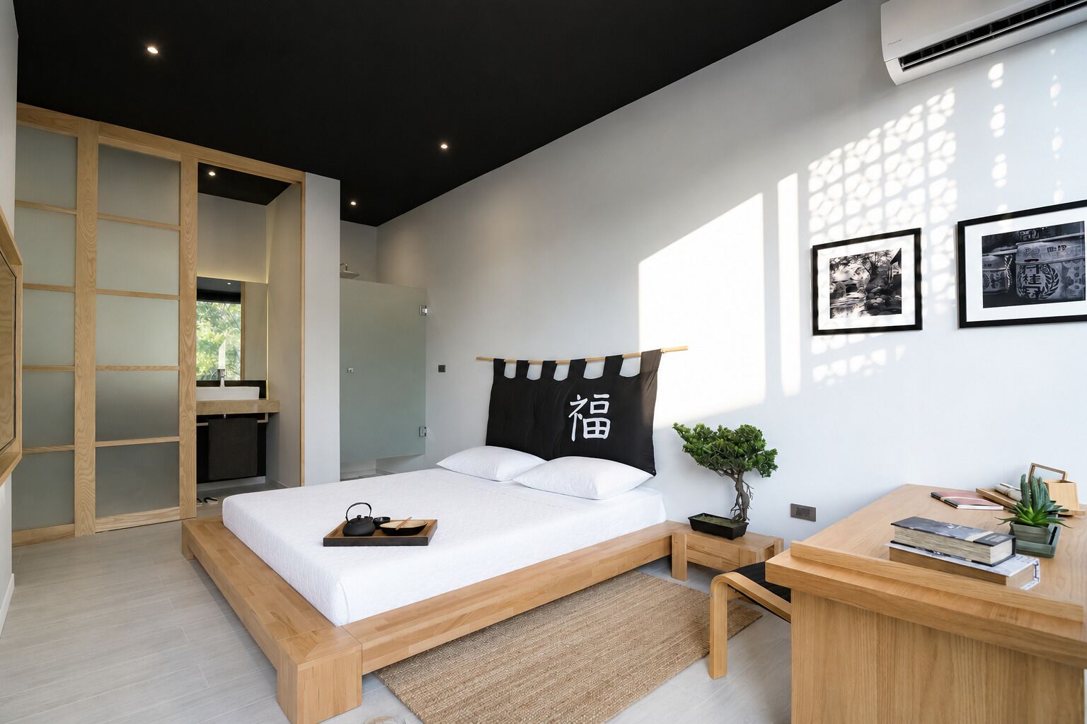 A modern bedroom with a bed, bedside table, and a desk with a plant.