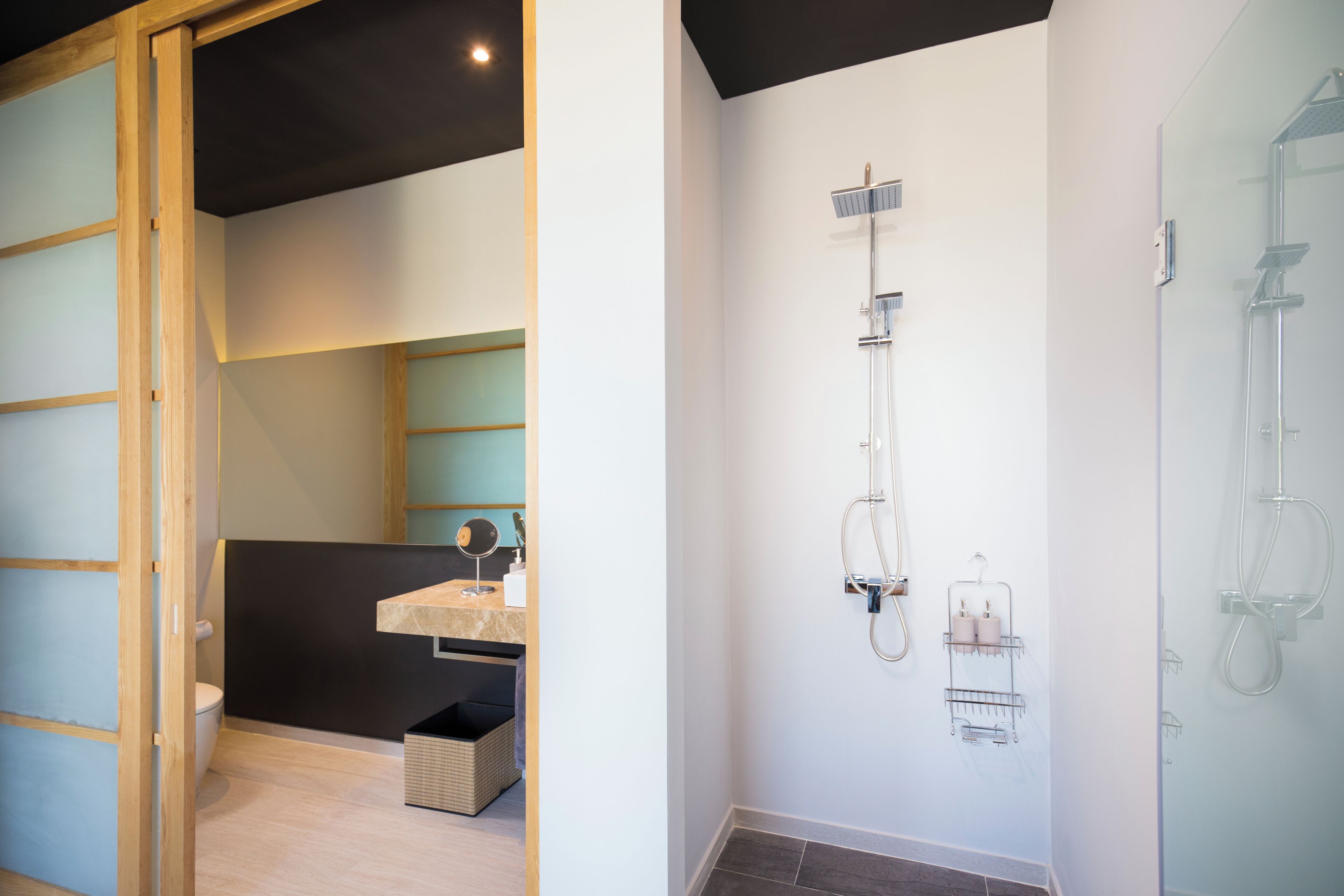 A modern bathroom with a shower, a sink, and a toilet.