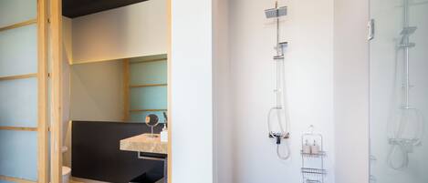 A modern bathroom with a shower, a sink, and a toilet.