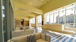 A spacious lobby with a checkered floor, large windows, and a seating area with a sofa and armchairs. - PINEART LABEL (Gangneung)