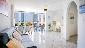 Una sala moderna con sofá, comedor y cocina.