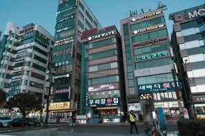 A multi-story building with various commercial establishments, including a 7-Eleven convenience store and a restaurant.
