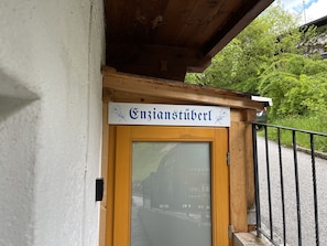 A wooden door with a sign above it that reads "Enzianstüberl".