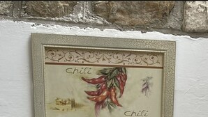 A chalkboard with handwritten text in a foreign language, surrounded by a decorative frame.