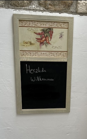 A chalkboard with handwritten text in a foreign language, surrounded by a decorative frame.