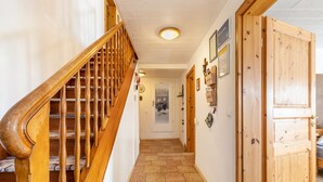 A hallway with a wooden staircase, a door with a small window, and a tiled floor. - Holiday Home 'em Biehl' with Spacious Garden (Ehingen (Donau))