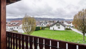 Un barrio residencial con casas, césped y un balcón de madera.