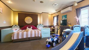 A hotel room with a bed, a desk, a television, and a toy car. - Ikaho no mori Kids Paradise (Yoshioka)