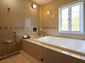 A bathroom with a bathtub, a shower, a toilet, a sink, and a window with blinds. - Ikaho no mori Kids Paradise (Yoshioka)