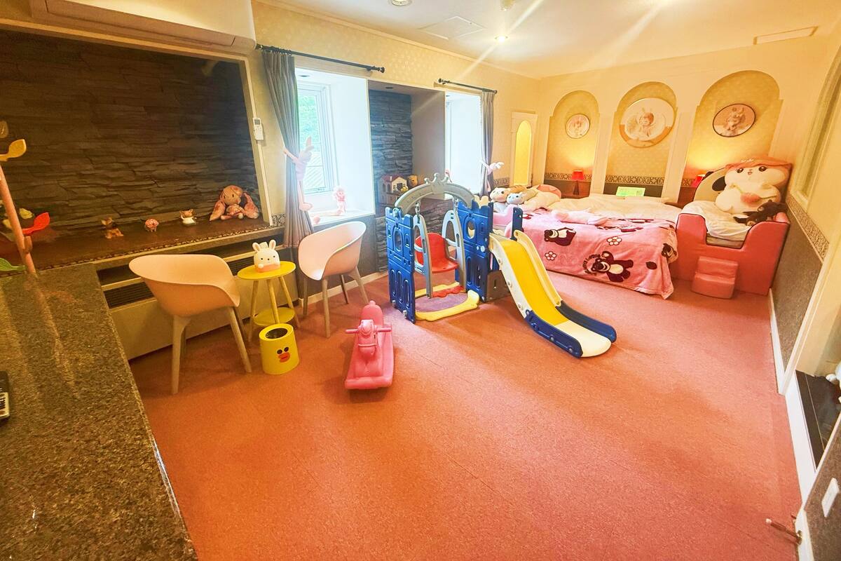A children's play area with a slide, playhouse, and seating.