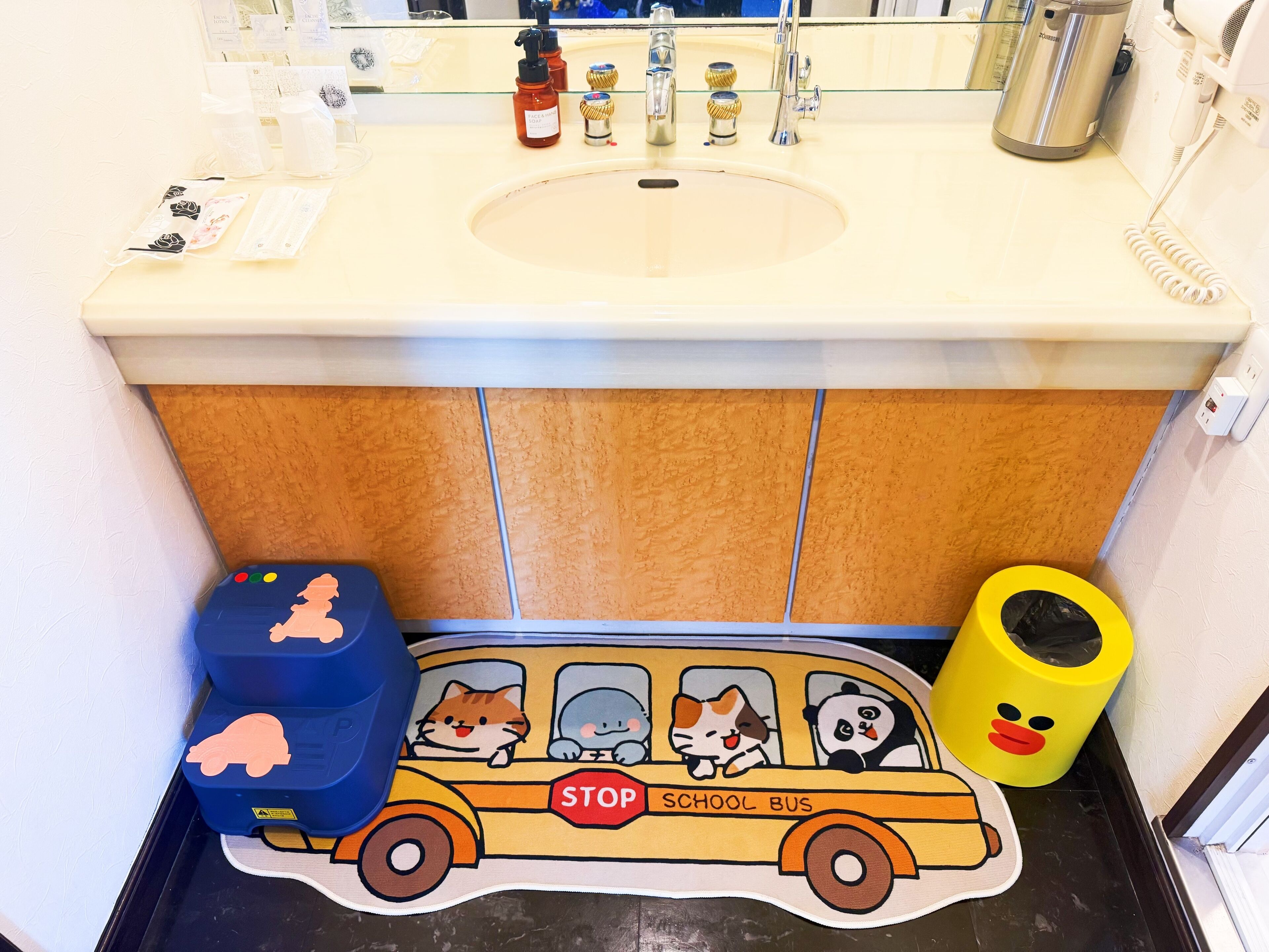 A bathroom with a sink, mirror, and toiletries.