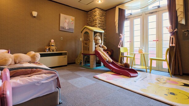 A children's play area with a slide, a playhouse, and a large teddy bear. - Ikaho no mori Kids Paradise (Yoshioka)