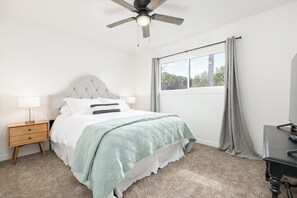 A bedroom with a bed, a nightstand, a desk, a ceiling fan, and a window with curtains. - The Big Dipper between Kaweah River & Skyline, SNP (Three Rivers)