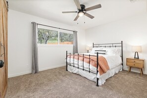 A bedroom with a bed, a ceiling fan, a window with curtains, and a bedside table with a lamp. - The Big Dipper between Kaweah River & Skyline, SNP (Three Rivers)