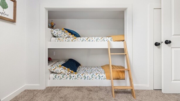 Uma cama beliche com escada, paredes brancas e uma porta.