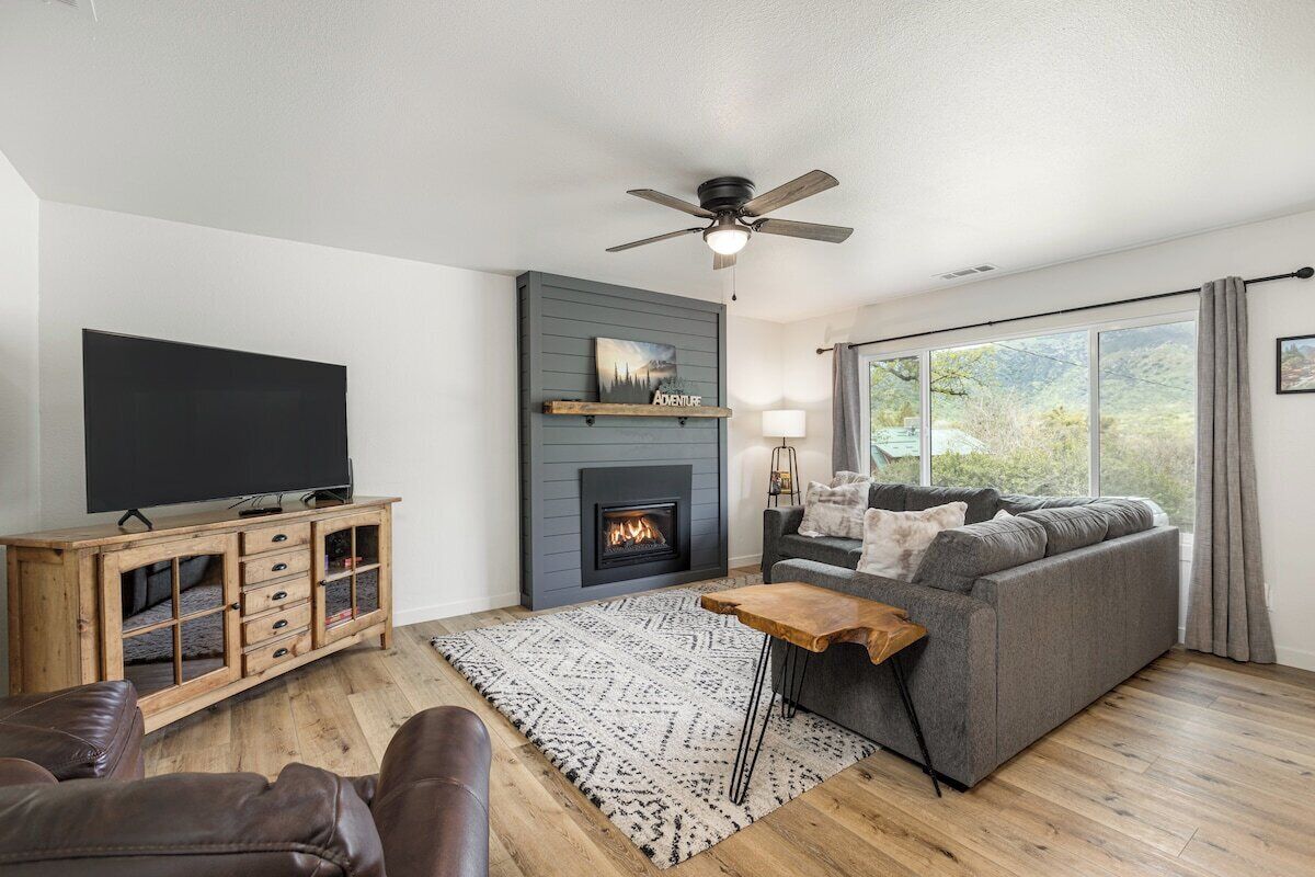 A modern living room with a fireplace, a television, and a sofa.