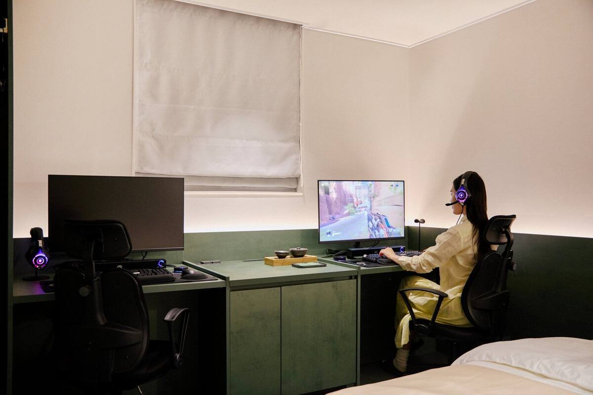 Une pièce comprenant un lit, un bureau avec un ordinateur et une chaise.