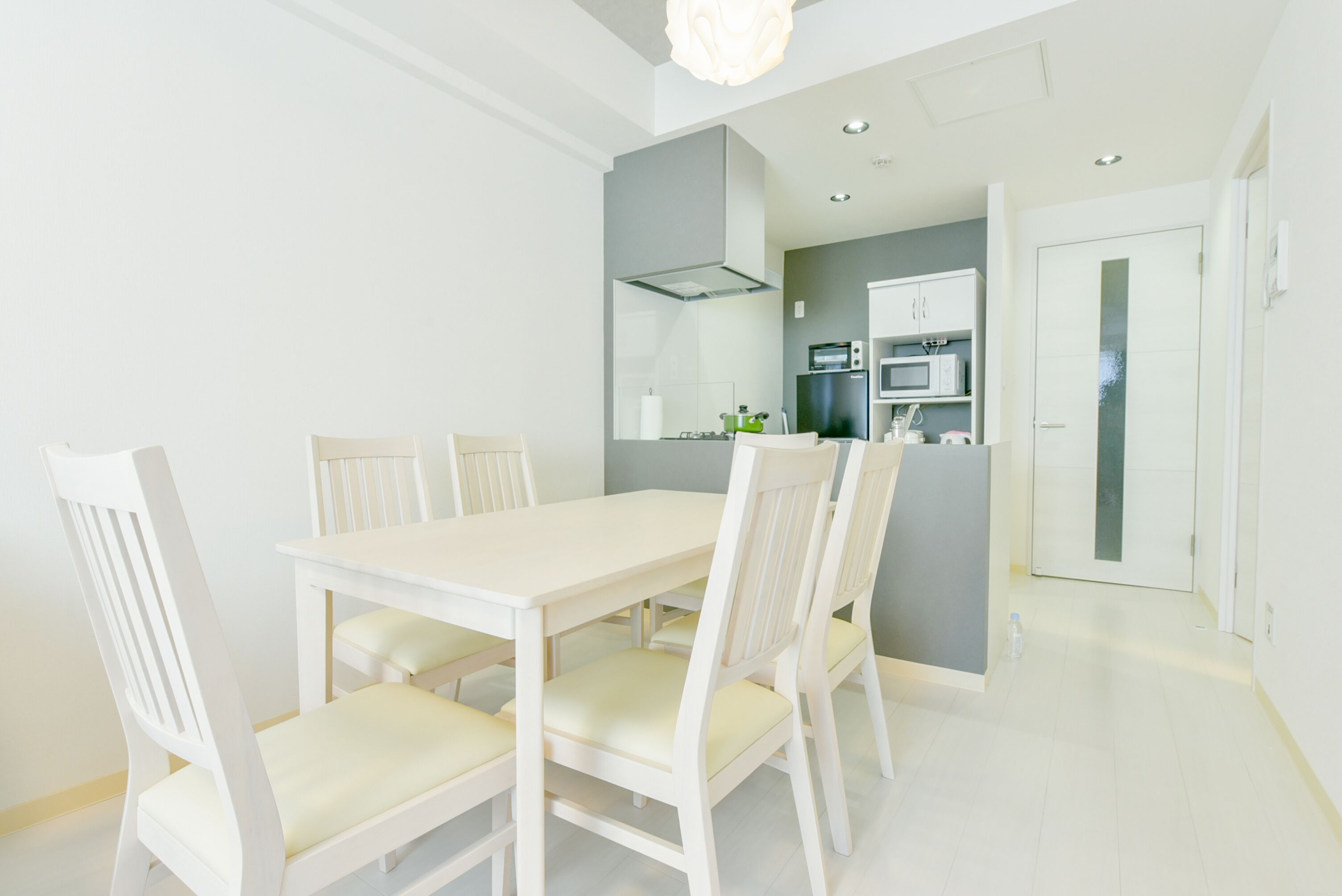 A modern kitchen with white cabinetry, a built-in oven, and a microwave.