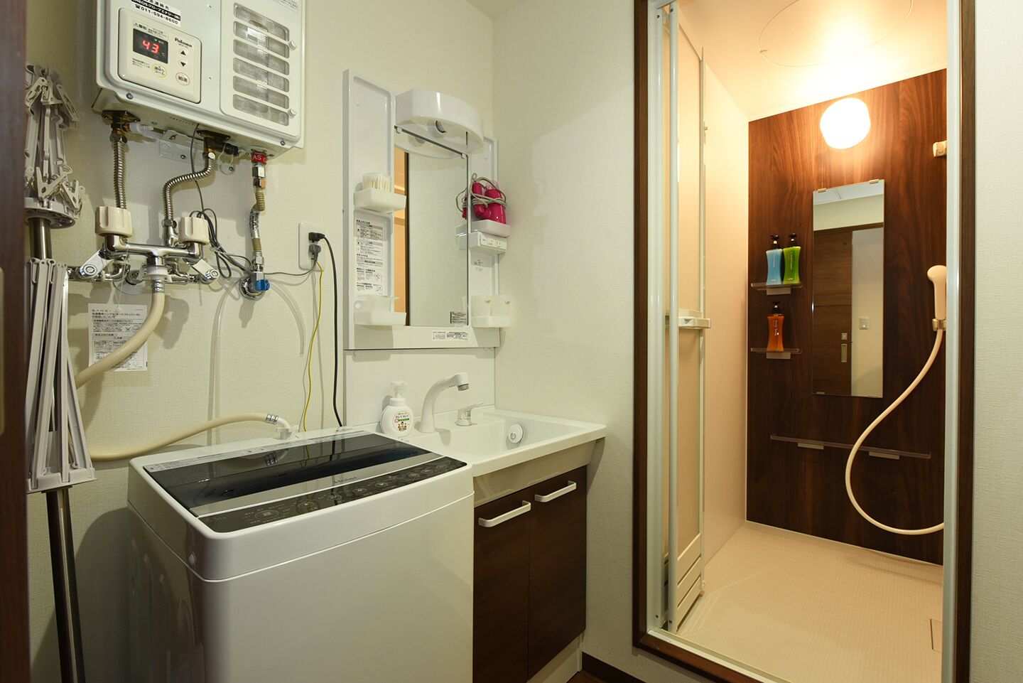 A bathroom with a sink, mirror, and shower.
