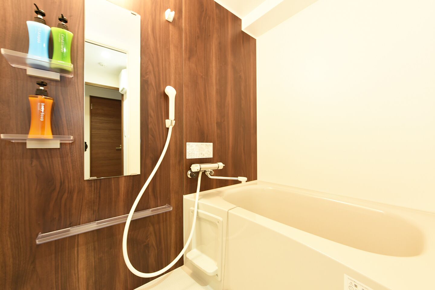 A modern bathroom with a wooden vanity, a mirror, and a bathtub.