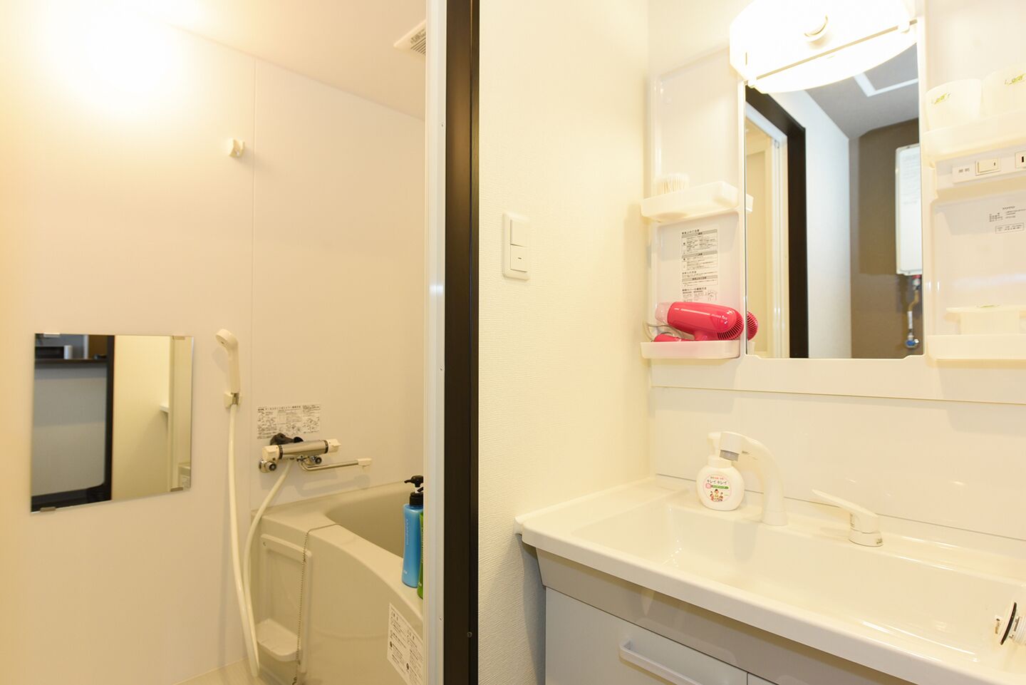 A bathroom with a bathtub, a sink, a mirror, and a shelf with toiletries.