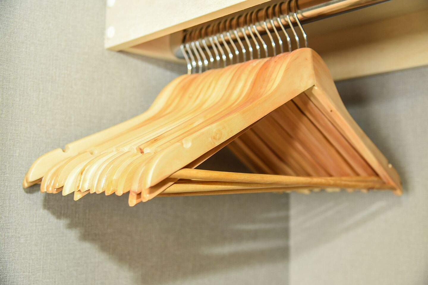 A wooden hanger rack with multiple hangers.