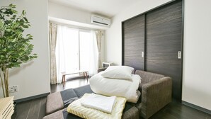 A modern hotel room with a bed, a seating area, a large window, and a plant. - Sun Court Hongodori Garden Hills (Sapporo)
