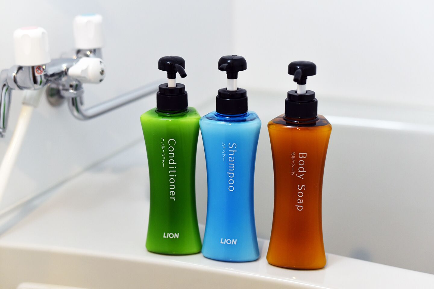 Three bottles of toiletries on a bathroom counter.