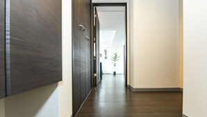 Passadís de fusta estret i fosc amb una porta al final que dona a una habitació.