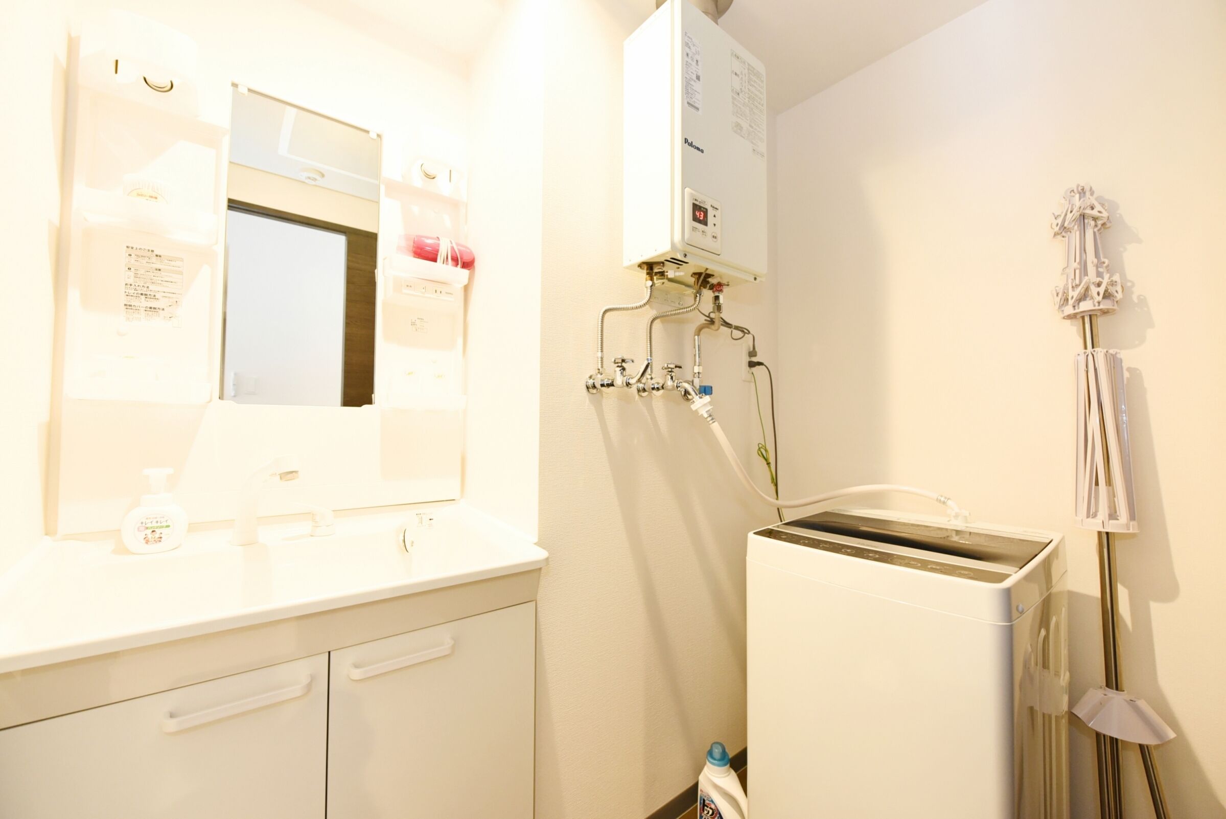 Une salle de bain avec un lavabo blanc, un miroir et un radiateur fixé au mur.