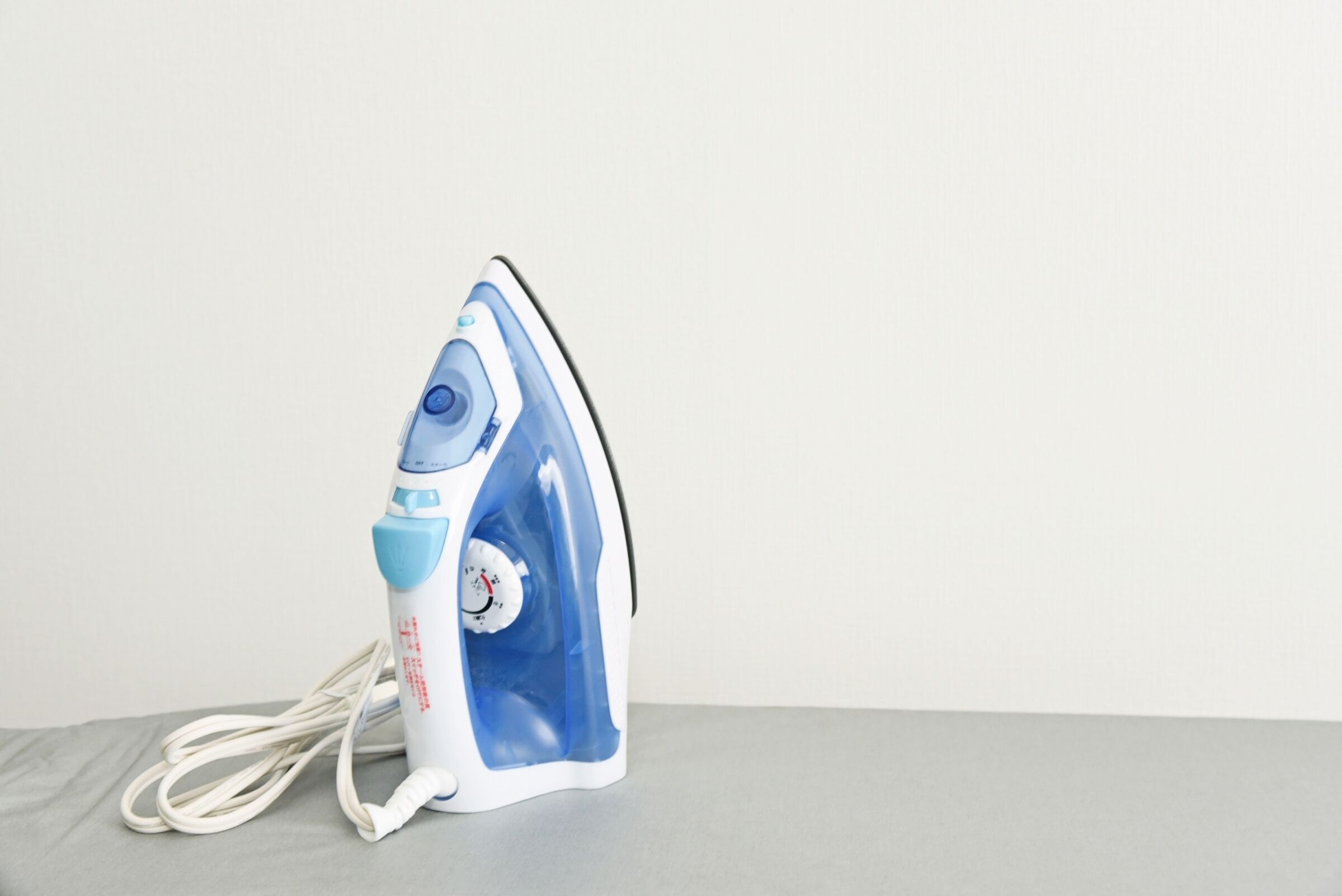 Un ferro da stiro compatto e portatile, con un design blu e bianco, dotato di display digitale e cavo di alimentazione.