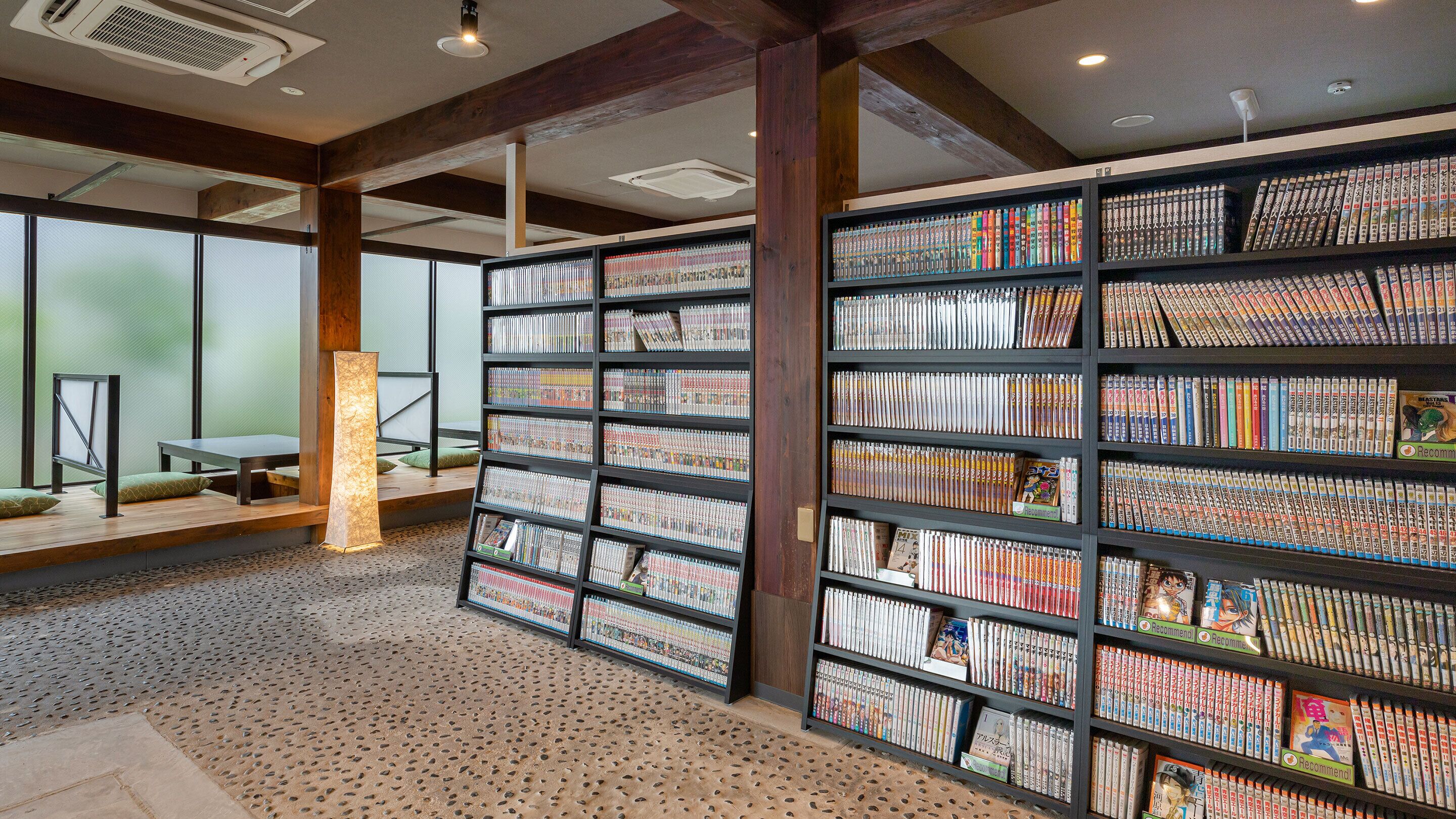Een bibliotheek met boekenkasten vol boeken, een houten tafel en een vloer met patroon.