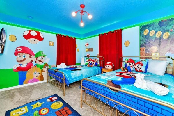 Een kamer met twee bedden, rode gordijnen en decoraties met een Mario thema.