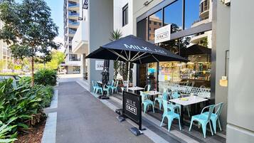 Relax in the shaded seating area of Milk Crate, where you can enjoy a meal amidst the sights of the surrounding city.