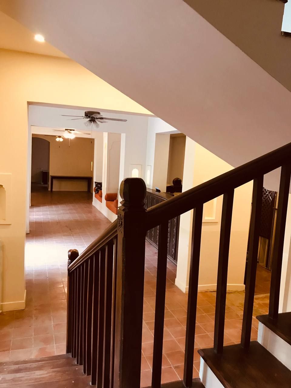 Un escalier avec une rampe en bois menant à un palier.