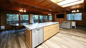 A spacious kitchen with wooden cabinets, a granite countertop, and a built-in dishwasher.
