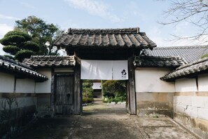Un torii japonés tradicional con techo de tejas y un estandarte colgado en la parte superior.