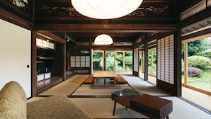 A traditional Japanese room with tatami flooring, a low wooden table, and sliding doors. - RITA Izumifumoto (Izumi)