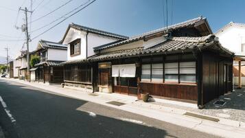 Un edificio japonés tradicional con tejado de tejas, fachada de madera y un letrero que indica una tienda de tabaco.