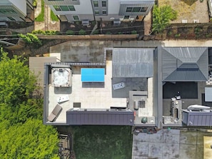 Vue aérienne d’un toit-terrasse avec une piscine, un espace salon extérieur et un petit jardin.