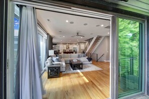 A spacious living room with a large sofa, coffee table, and a staircase leading to an upper level.