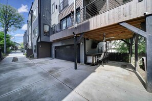 A modern residential building with a covered patio area, a garage, and a visible address number. - 906 Westbrook B  · City Views RoofTop Hot Tub & Short Walk to Stadium (Charlotte)