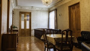 Una sala da pranzo con un lampadario, arredi in legno e carta da parati decorata.