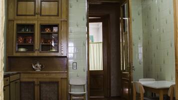 Una cocina con armarios de madera, piso a cuadros y una ventana con cortinas.