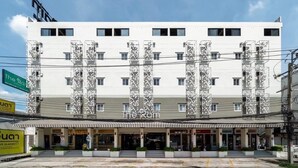 Un hotel de varios pisos con fachada blanca y columnas decoradas.